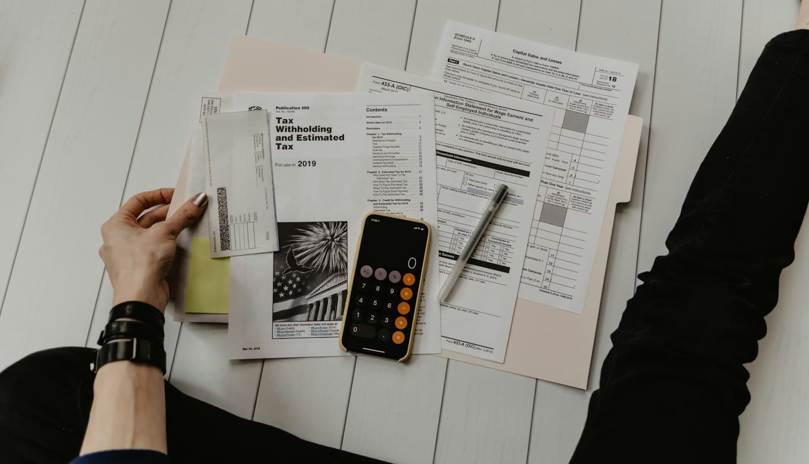 Invoices, a calculator and a phone on a desk